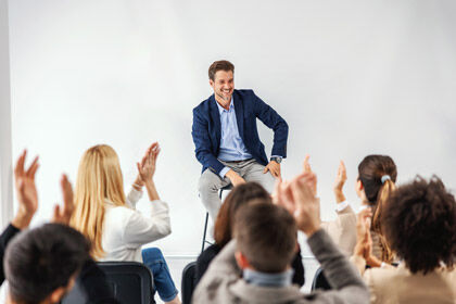 ein Mann, der auf einem Stuhl vor einer Menge steht