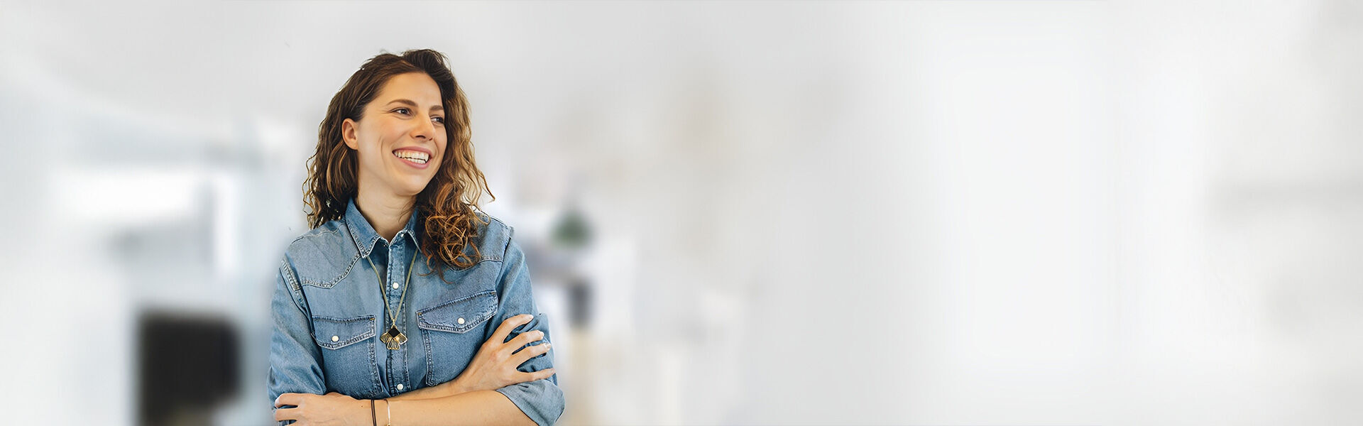 eine Frau, die mit gekreuzten Armen in einem Raum steht